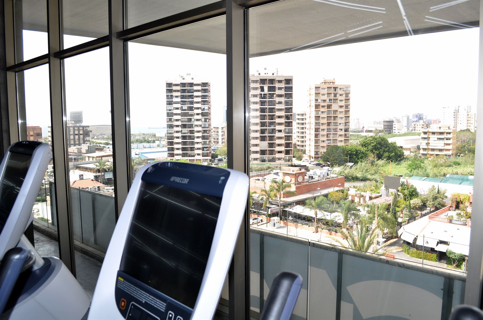 Cardio machines facing windows with sea and city views